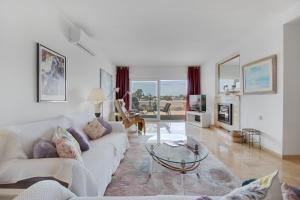 uma sala de estar com um sofá branco e uma mesa em Lujoso apartamento con alucinantes vistas al golf - Iwii A 38 em Marbella