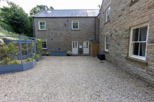 een bakstenen huis met een binnenplaats ervoor bij The Applery, Leyburn Yorkshire Dales National Park in Leyburn