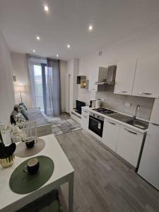 a kitchen with white appliances and a table in a room at Appartamento New: Lingotto in Turin