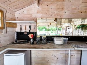 cocina con paredes de madera y encimera en Les chambres du Roc, en Le Roc