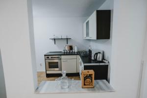 uma cozinha com um fogão e uma mesa com uma caixa em Apartman Daris 2 em Sarajevo