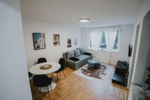 uma sala de estar com uma mesa e um sofá em Apartman Daris 2 em Sarajevo