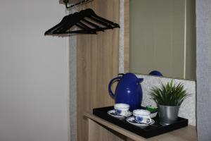 a black shelf with a blue pitcher and cups on it at Orange House in the Old Town Plovdiv in Plovdiv