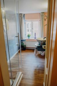ein Bad mit einer Dusche und einem Waschbecken in der Unterkunft sleepArt room for 2 in Celle