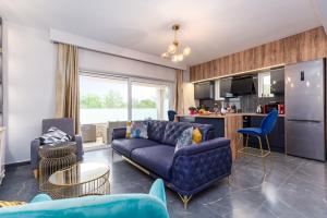 a living room with a blue couch and a kitchen at Nightingale Villa & Suites Corfu in Gazátika