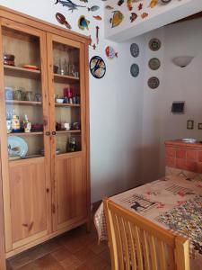 Zimmer mit einem Tisch und einem Schrank mit Platten an der Wand in der Unterkunft Casa Marina Taormina in Taormina