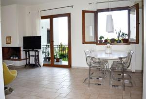 a living room with a table and chairs and a television at Elektra Apartment-Kallithea in Kallithea Rhodes