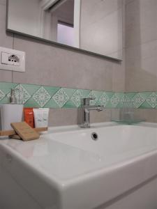 um lavatório branco na casa de banho com um espelho em Casa dei Gemelli em Minori