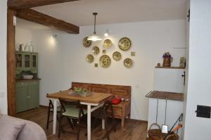 Urych的住宿－Садиба Злата хата，厨房配有桌子和盘子,墙上挂着