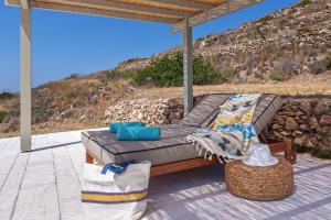 a chaise lounge on a patio with a view of the ocean at Syros Grace eco-Villa with Jacuzzi & Stuning Views in Ano Syros +48 photos