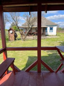 una vista de una casa desde un porche con un banco en Бабусина хатка, en Leplyavo