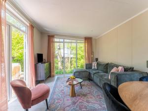 a living room with a couch and a table at Luxury chalet near Ouddorp with garden in Goedereede