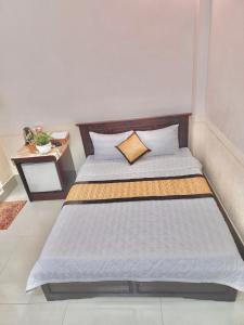 芹苴的住宿－NAMA HOTEL - Ninh Kieu Center，一间卧室配有一张大床和木制床头板