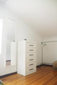 um quarto com uma cómoda branca e um espelho em Casa da Castañuela em Muros
