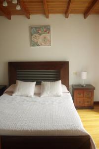 um quarto com uma cama grande e uma cabeceira em madeira em Casa da Castañuela em Muros