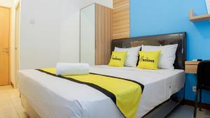 um quarto com uma cama grande e almofadas amarelas em My Rooms at Paskal Hyper Square em Bandung