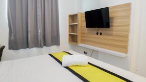 una camera da letto con un letto e una TV a parete di My Rooms at Paskal Hyper Square a Bandung