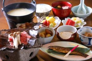 a table with a plate of food and other foods at Iroriyado Hidaya in Takayama