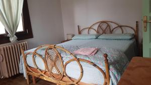 a bedroom with a bed with a wooden frame at Affittacamere Bocca d'Orso in Altare +9 photos