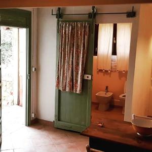 baño con puerta verde y aseo en Affittacamere Bocca d'Orso, en Altare