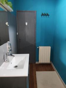 La salle de bains est pourvue d'un lavabo blanc et d'un miroir. dans l'établissement Les Bibasses, à Aillas