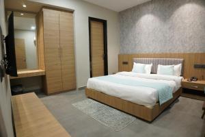 a bedroom with a large bed and a mirror at HOTEL CENTRAL PARK in Bathinda