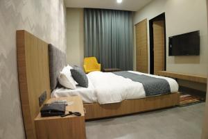 a hotel room with a bed and a television at HOTEL CENTRAL PARK in Bathinda +2 photos