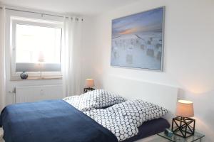 グレーミッツにあるApp-Haus "Max & Moritz" - Whg 9 - nur wenige Schritte zum Strand und zum Einkaufenのベッドルーム1室(ベッド1台付)が備わります。壁に絵が飾られています。
