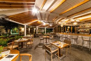 un ristorante con tavoli e sedie e un bar di Skiathos Avaton Hotel, Philian Hotels & Resorts a Città di Skiathos