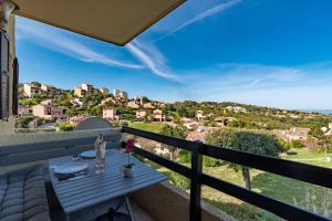 einen Balkon mit einem Tisch und Aussicht in der Unterkunft Kallistea - Appartement avec vue mer in Porticcio