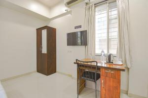 een kamer met een houten bureau en een raam bij FabHotel Skylight Studio Rooms in Pune