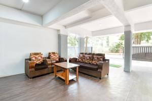 een woonkamer met 2 banken en een tafel bij FabHotel Skylight Studio Rooms in Pune