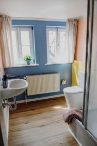 uma casa de banho com um lavatório e um WC em sleepArt room for 3 em Celle