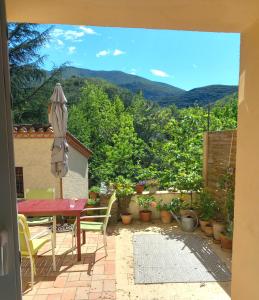 a patio with a table and chairs and an umbrella at Maison Do Mi Sol in Reynès