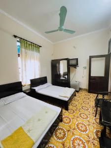 a bedroom with two beds and a ceiling fan at Nhà Nghỉ Trường Lệ in Sầm Sơn