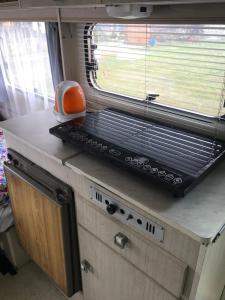 una cocina con una parrilla en una encimera con una ventana en PRZYCZEPA CAMPINGOWA Ogrzewana !!temperatura 17lub 18stopni ZAKOPANE en Zakopane