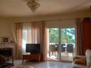 a living room with a television and a sliding glass door at Villa Alemania in Altea