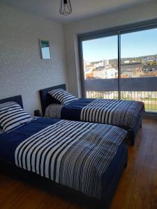 3 Betten in einem Zimmer mit einem großen Fenster in der Unterkunft Bienvenue au Caton in Tarbes