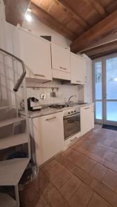 una cucina con armadi bianchi e piano cottura di Casa vacanze Iris a Todi