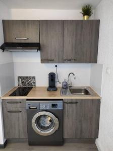 a kitchen with a washing machine and a sink at Charmant studio climatisé 24 m2 terrasse à 100m de la plage in Saint-Mandrier-sur-Mer