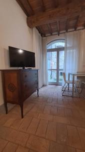 een woonkamer met een televisie op een dressoir en een tafel bij Casa vacanze Iris in Todi