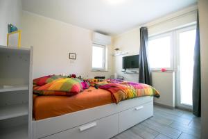 une chambre avec un grand lit avec des oreillers colorés dans l'établissement Rooms Apartim 2 Piran, à Piran