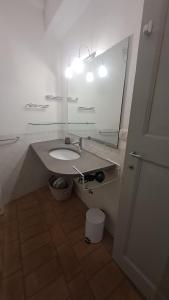 een badkamer met een wastafel en een grote spiegel bij Casa vacanze Iris in Todi