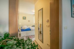 a hallway with a mirror and a bed in a room at Rooms Apartim 2 Piran in Piran