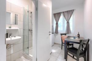 uma casa de banho com um lavatório e uma mesa com um lavatório em Hostel Monte Zaro em Pula