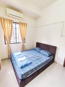 a bedroom with a bed with a blue comforter at Puchong Semi D Homestay spacious 4 rooms in Puchong