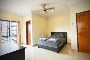 a bedroom with a bed and a ceiling fan at Puchong Semi D Homestay spacious 4 rooms in Puchong