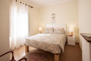 um quarto branco com uma cama e uma janela em El Jardí de Can Prat em Ripoll