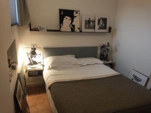 - une chambre avec un lit, un bureau et des photos sur le mur dans l'établissement Bogliasco a due passi dal mare, à Bogliasco