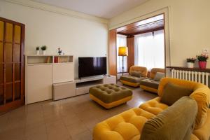 sala de estar con muebles de color amarillo y TV en El Jardí de Can Prat, en Ripoll